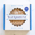 A Blue Ribbon pie box with an apple streusel pie on top