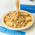 An apple streusel pie with streusel being poured on top