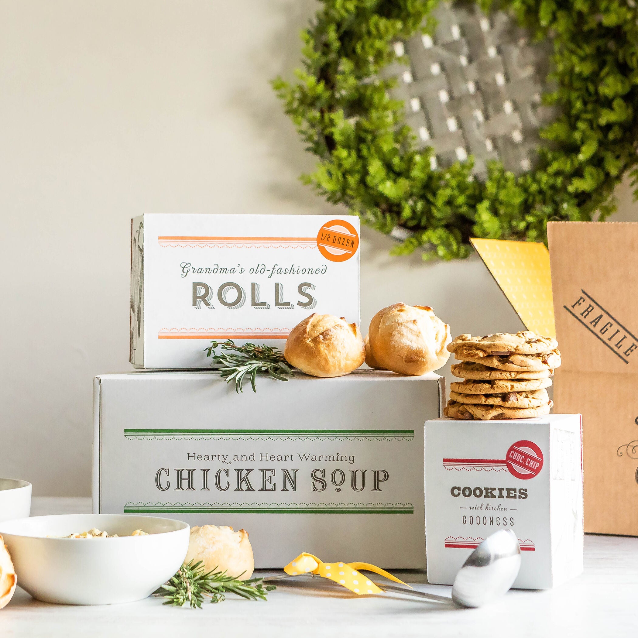 Stacked boxes of Spoonful of Comfort's chicken noodle soup, cookies, and rolls.